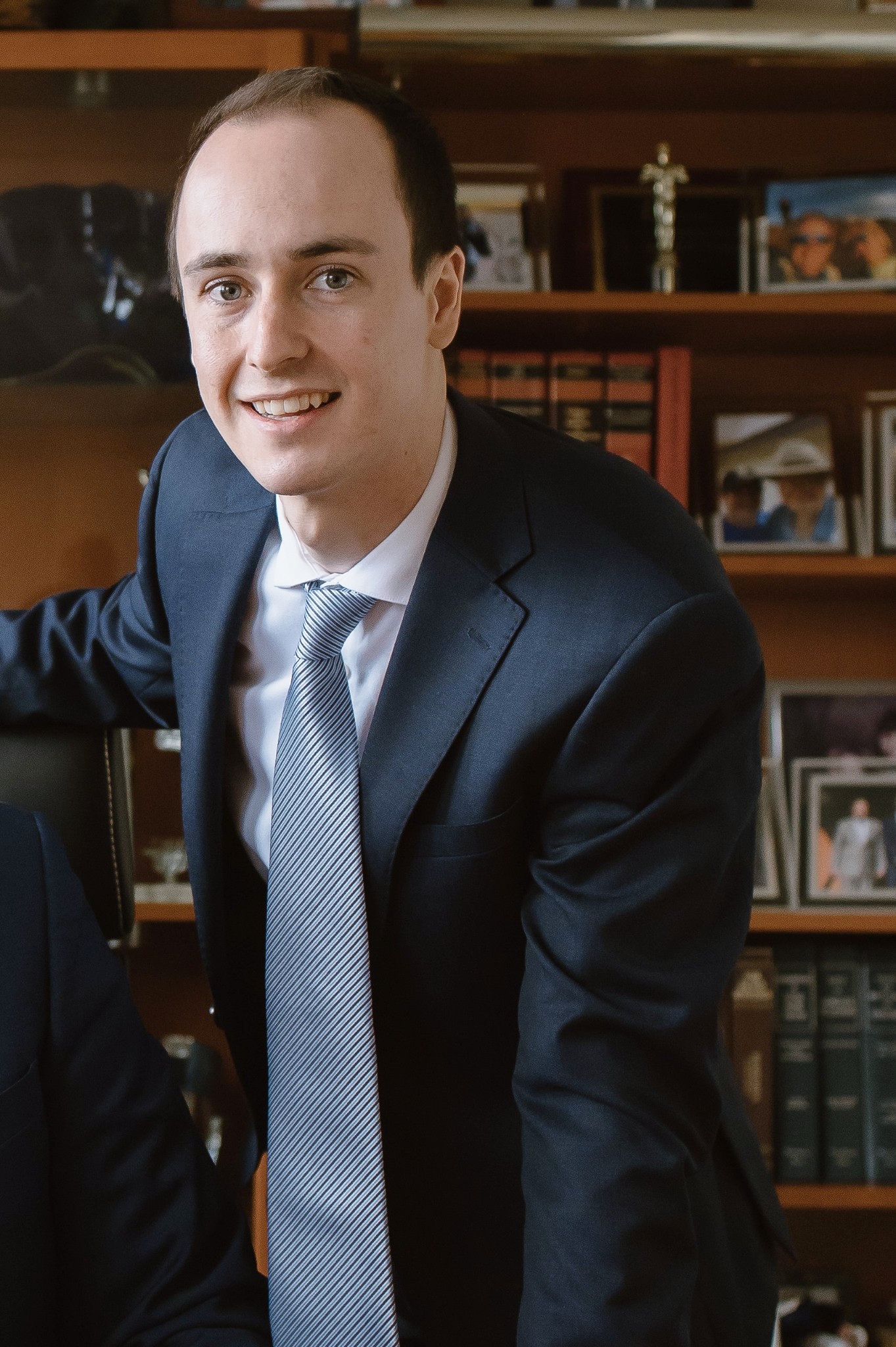Logan standing with his hand on an office desk